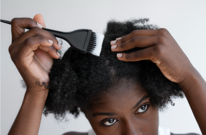 African female applying treatment to natural hair