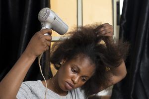 African female blow drying hair